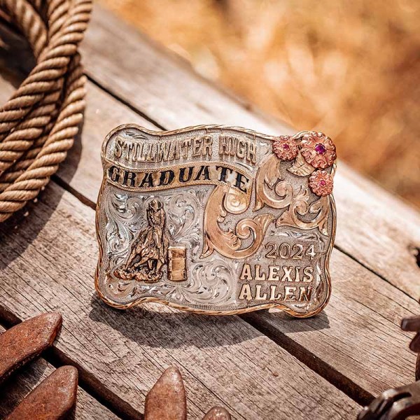 A custom graduation belt buckle for Stillwater High School graduate featuring a barrel racing cowgirl figure 